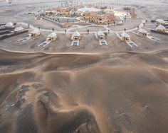 an aerial view of a desert with buildings and sand dunes