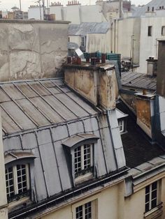 an image of rooftops in paris with roofs made of metal sheeting and windows