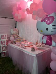 a hello kitty birthday party with balloons and cake