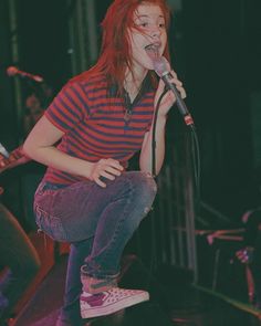 a woman standing on top of a stage holding a microphone