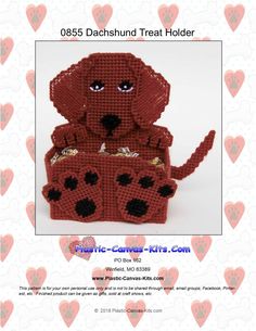 a crocheted red dog sitting on top of a box