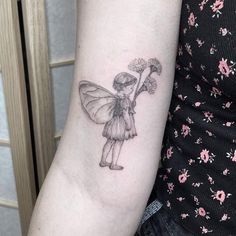 a small tattoo on the arm of a girl with a flower in her left hand