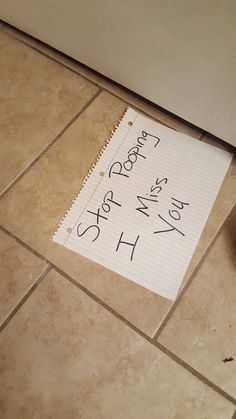 a piece of paper that has been written on the floor next to a door with writing on it