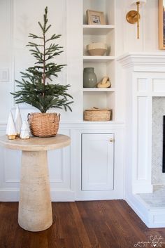 a small christmas tree sits on top of a table in the corner of a room