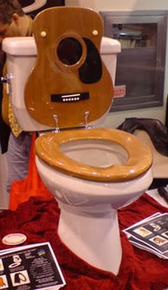 a wooden toilet seat sitting on top of a white toilet