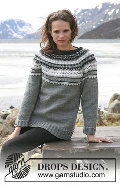 a woman is sitting on a bench wearing a sweater with an openwork pattern and mountains in the background