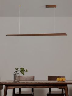 a wooden table with some fruit on it and a light hanging from the ceiling above