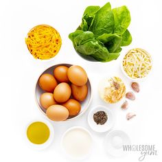 eggs, cheese, spinach and other ingredients on a white surface