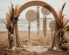 an outdoor ceremony set up on the beach with pamolite and dried grass decor