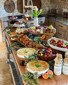 a table filled with lots of food on top of a wooden counter