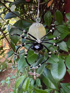 a glass spider ornament hanging from a tree