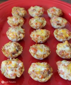 mini pizzas with cheese and meat are on a red plate, ready to be eaten