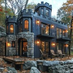 a house made out of shipping containers in the woods with lots of trees and rocks