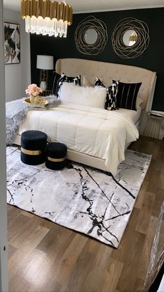 a bedroom with black and white decor on the walls, wood flooring and a large bed