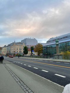 people are riding bikes down the street on a cloudy day