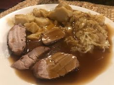 a white plate topped with meat and gravy