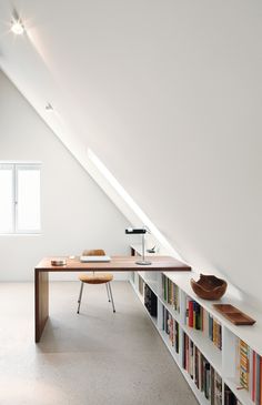 an attic office with bookshelves and desk