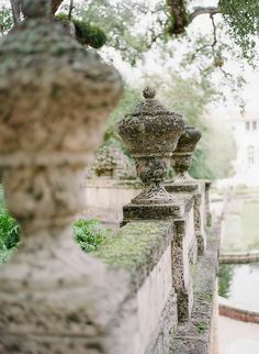 an old stone fence with moss growing on it