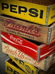 several wooden crates stacked on top of each other with coca - cola signs above them