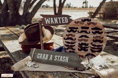 two wooden signs that say wanted, grab a stash and one with mustaches