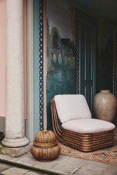 a wicker chair sitting on top of a rug next to a vase and door