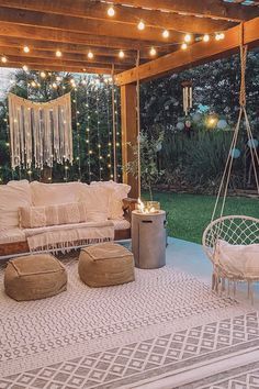 an outdoor seating area with lights strung from the ceiling and hanging chairs on the floor