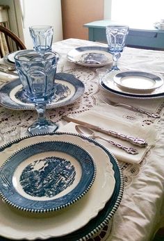 a table set for two with plates and silverware on it, along with place settings