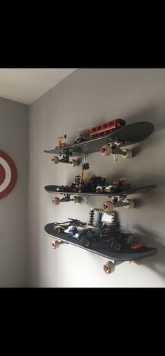 three skateboards mounted to the side of a wall with legos on top of them