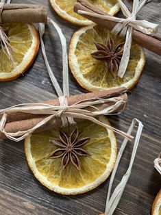 orange slices with cinnamon stick and star anise tied to them on a wooden table