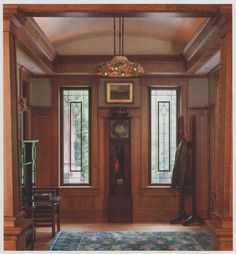 a room with wood paneling and two large windows on the side of the wall