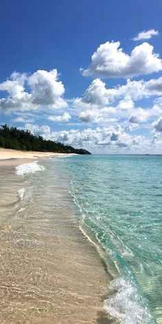 the beach is clear and blue with waves coming in