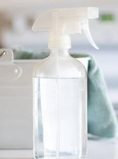 a close up of a bottle on a table with a hand towel in the background