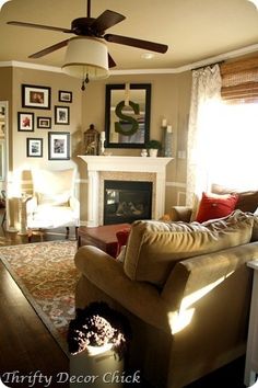 a living room filled with furniture and a fire place under a ceiling fan on top of a hard wood floor