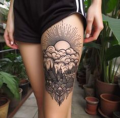 a woman's thigh with an intricate tattoo design on her leg and the sun in the sky