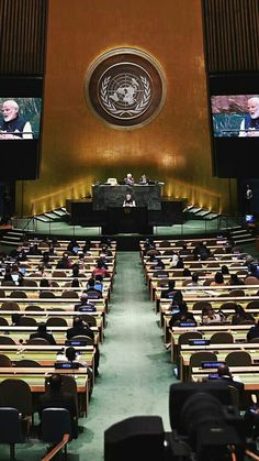 the un general assembly hall is empty for people to sit at their desks in front of them