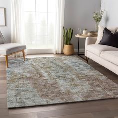 a living room area with a couch, chair and rug in front of a window