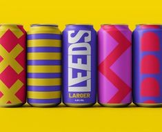 six different types of soda cans lined up in a row on a yellow background with the same color