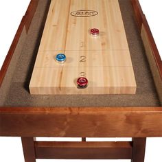 a wooden table with several different colored buttons on the top and one red button at the bottom