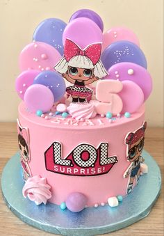 a pink birthday cake decorated with lol surprisers balloons and an image of a doll