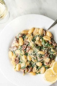 a white plate topped with pasta and spinach