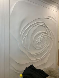 a white wall with swirls on it and a bottle of water next to it