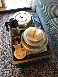 the tray is full of coffee and other items on the table in front of the couch