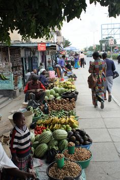 an outdoor market with many different types of fruits and veggies on the tables