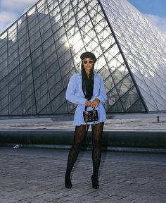 a woman standing in front of a very tall pyramid