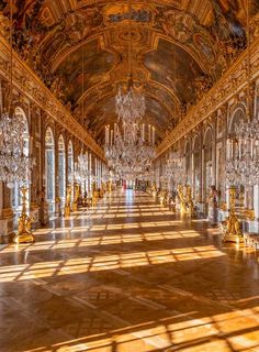 an ornate hall with chandeliers and windows in the center is lit by sunlight