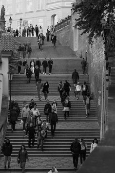 many people are walking up and down the stairs in this black and white photo,