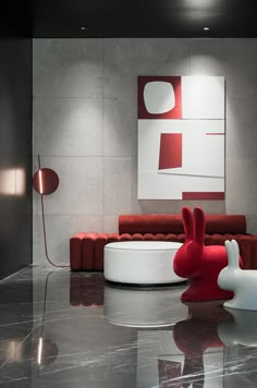 a modern living room with red and white furniture on the floor, in front of a large abstract painting