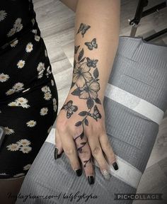 a woman's arm with flowers and butterflies tattooed on her left hand, next to a suitcase