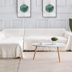 a white couch sitting next to a table on top of a carpeted living room floor