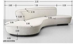 a white couch sitting on top of a floor next to a table with measurements for it